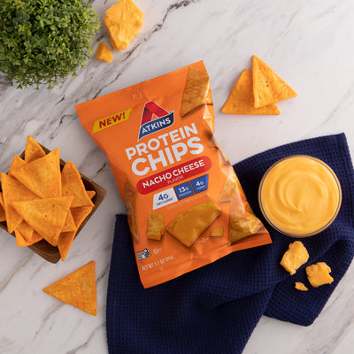 Nacho Cheese Snack Protein Chips with nacho cheese on blue cloth and marble table