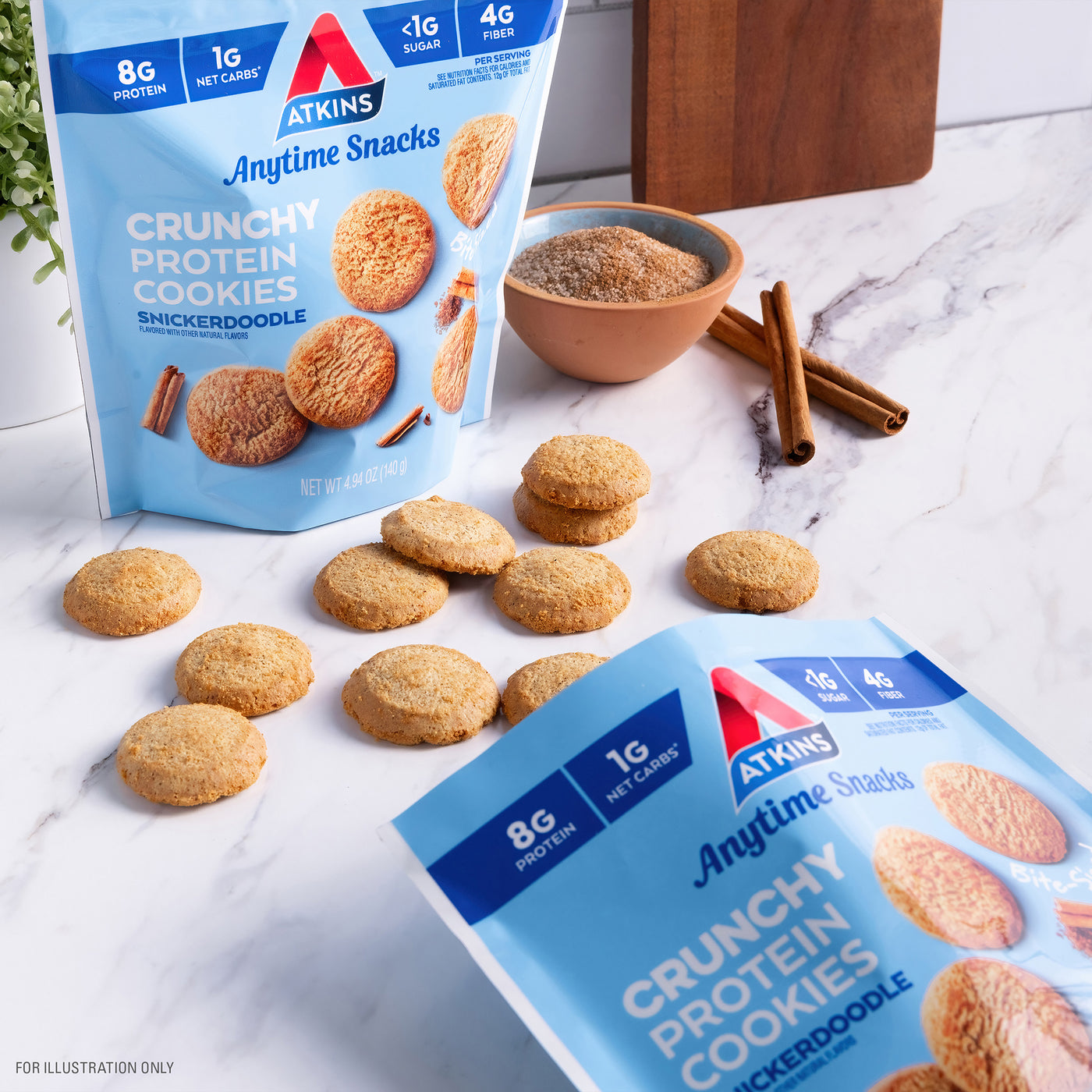 Snickerdoodle Bite-Sized Crunchy Protein Cookies with cookies on the marble table, bowl of cinnamon sugar and blue cloth next to it.