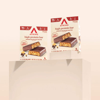 Two boxes of Atkins high protein bars on a beige background