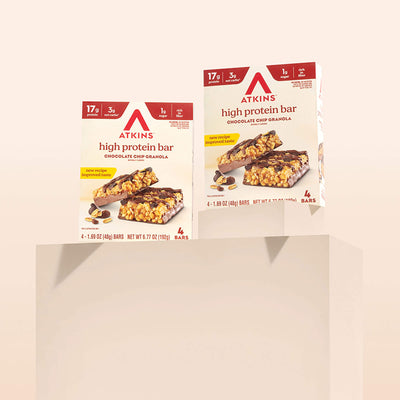 Two boxes of Atkins high protein bars on a beige background