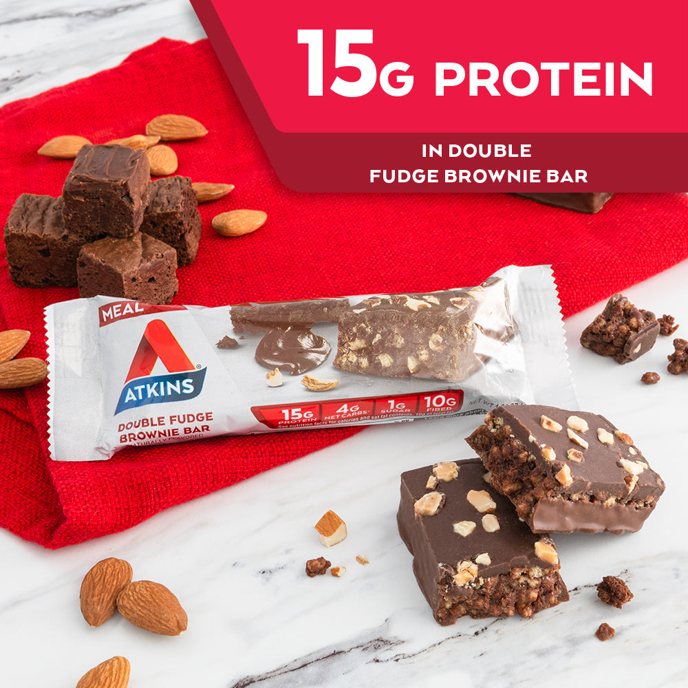 Double Fudge Brownie Bar with almond and chocolate next to it on a marble table; 15G Protein in Double fudge brownie bar